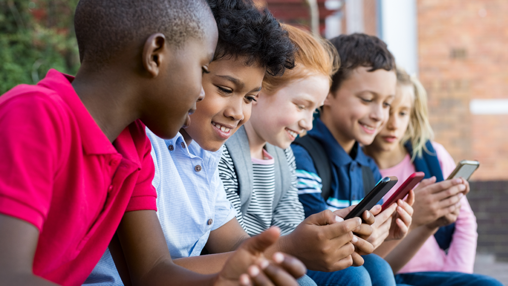 Kids looking at phone; 5 Reasons We're Cautious About Facebook’s Plans to Launch Instagram for Kids